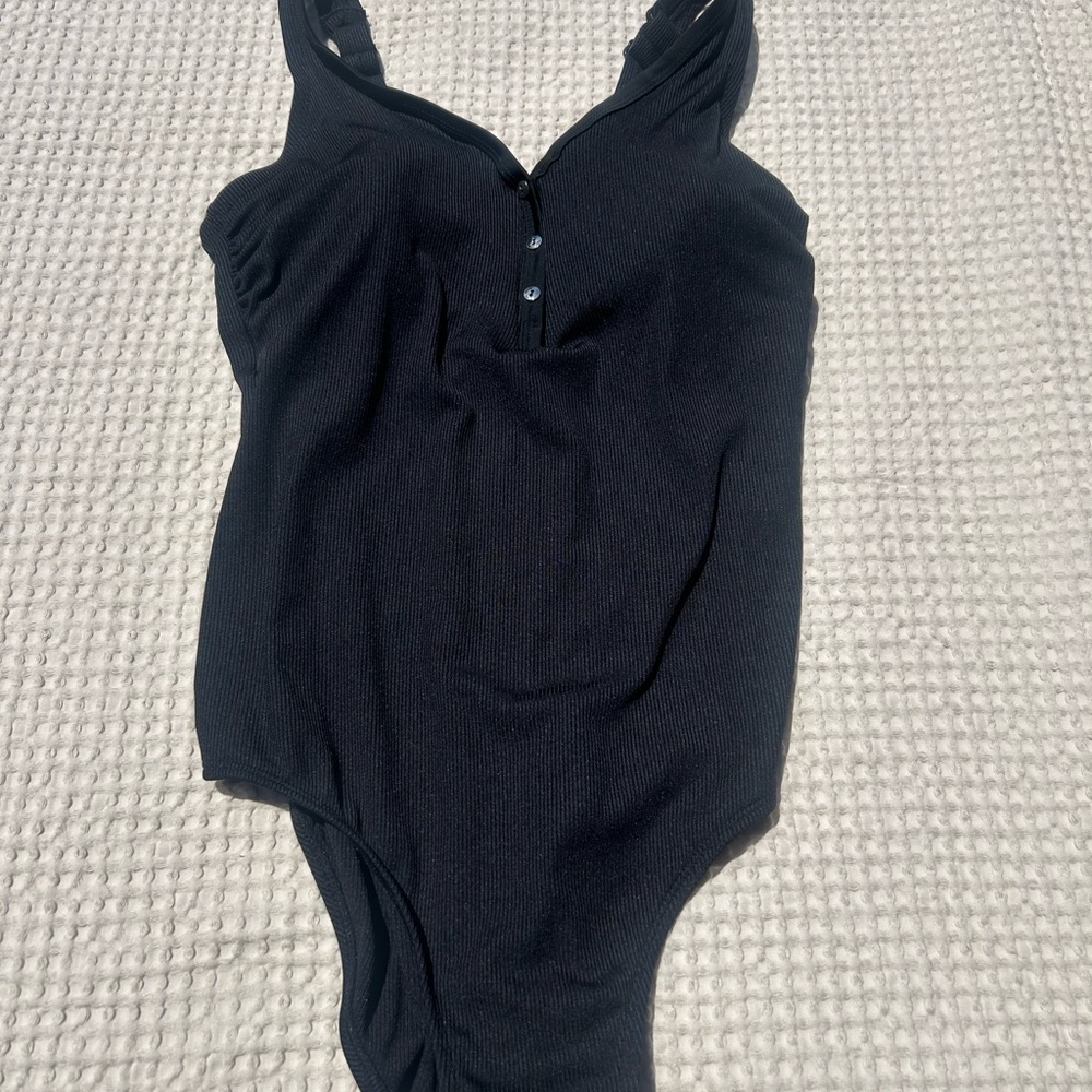 Stylish Black womans swimsuit with silver button details.